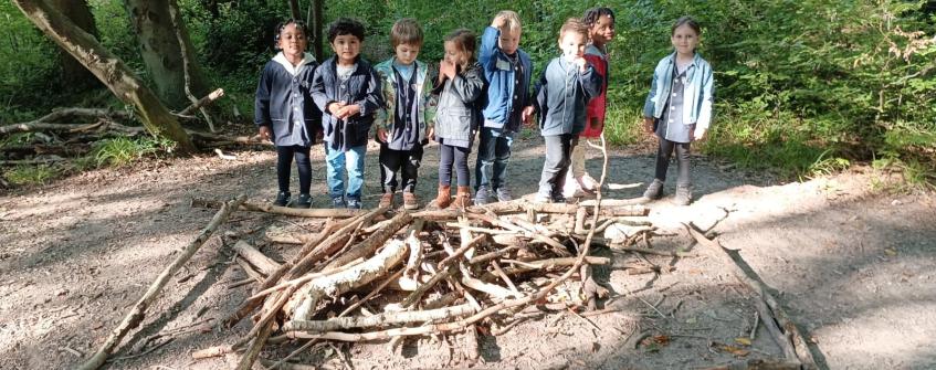 Les élèves se retrouvent autour de leur création dans la forêt.